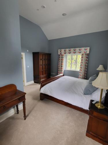 Un dormitorio con una cama grande y una ventana en The Coach House en Dublín