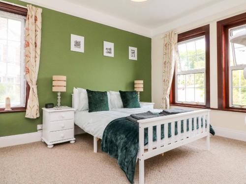 a bedroom with green walls and a bed and windows at Uptop in Dartmouth