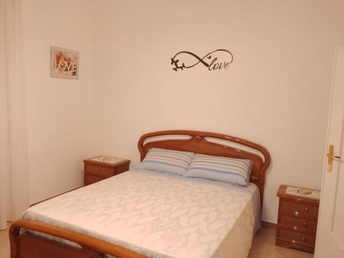 a bedroom with a bed and a sign on the wall at A' Ches du' Mestr 1 in Montalbano