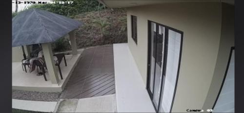 a balcony with a table and an umbrella on a house at California in Anapoima