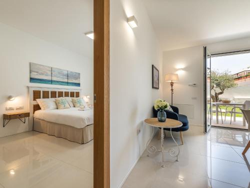 a bedroom with a bed and a table with a chair at Luxury Poetto Apartments in Cagliari
