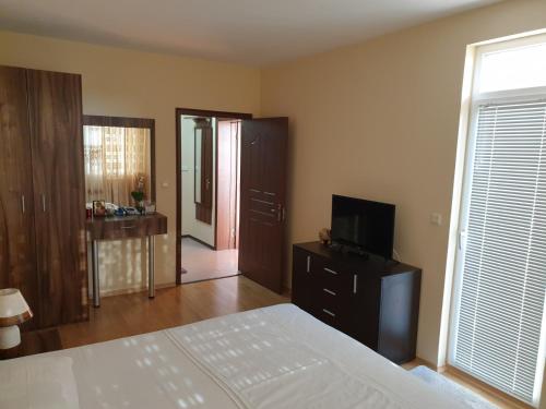 a bedroom with a bed and a television on a dresser at Sunny House Family in Nesebar