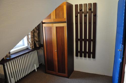 a hallway with a wooden cabinet and a stair case at Hostel Pestalozza in Špindlerův Mlýn