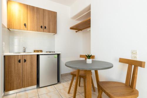a small kitchen with a table and a sink at Sea & Sun Paros in Naousa