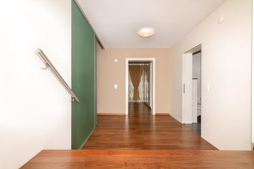 an empty hallway with green and white walls and wood floors at Hotel Swiss Views in Hemberg