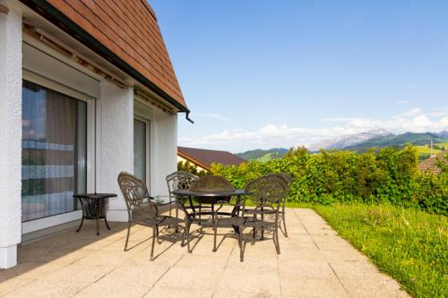 a patio with a table and chairs on a balcony at Hotel Swiss Views in Hemberg