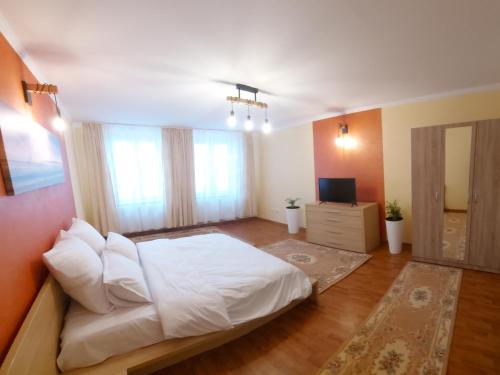 Schlafzimmer mit einem weißen Bett und einem TV in der Unterkunft Rhs Host in Bistriţa