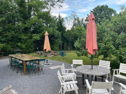 a patio with tables and chairs and an umbrella at Gite La Cigogne in Couvin