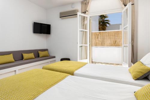 a bedroom with two beds and a window at Sea & Sun Paros in Naousa