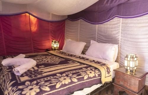 ein Schlafzimmer mit einem großen Bett in einem Zelt in der Unterkunft Erg Chegaga Camp Excursions in M’hamid El Ghizlane