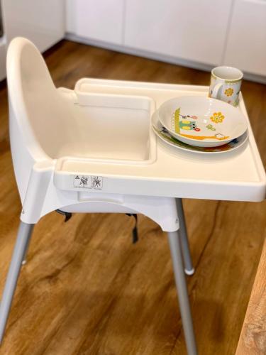 a white high chair with a plate on it at Apartmány DOME in Doksy
