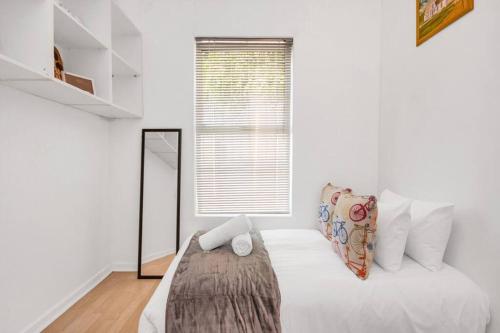 1 dormitorio con cama con espejo y ventana en Working Professionals, Modern, Cozy, WiFi, en Ciudad del Cabo