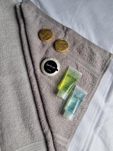 a gray sweater with buttons and money on a bed at SEA VIEW STAY 17 Princes Road in Great Yarmouth