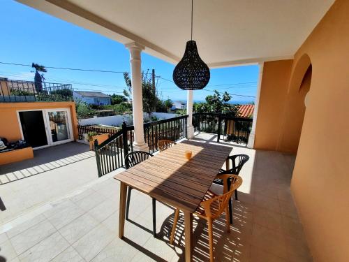 a wooden table and chairs on a patio at Sunset House in São Julião