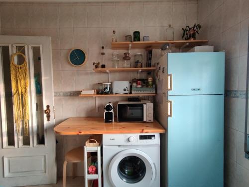 a kitchen with a refrigerator and a washing machine at Beach Front Apartment in Gafanha da Nazaré