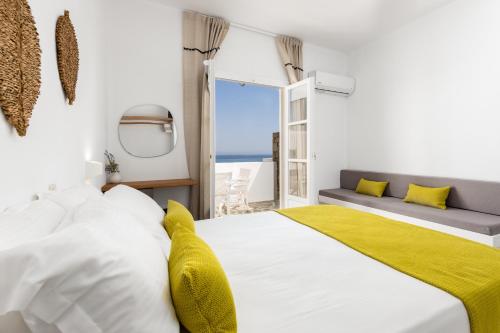 a bedroom with a large white bed with a yellow blanket at Sea & Sun Paros in Naousa