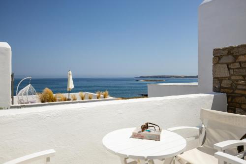 a table and chairs on a balcony with a view of the ocean at Sea & Sun Paros in Naousa