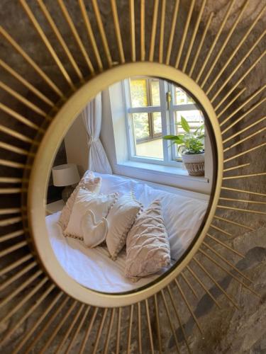 a bedroom with a bed in a round mirror at Vulcan Lodge Cottages in Rhayader