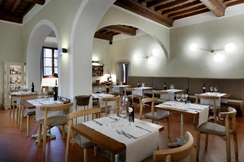 a dining room with tables and chairs in a restaurant at Tenuta di Artimino member of Meliá Collection Wine Resort in Artimino