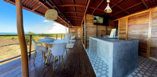 a room with a table and chairs on a deck at Corazon Guajiro Cabaña frente a Playa Solitaria en Dibulla cerca a Palomino - Cabin in front of Solitary Beachs in Dibulla