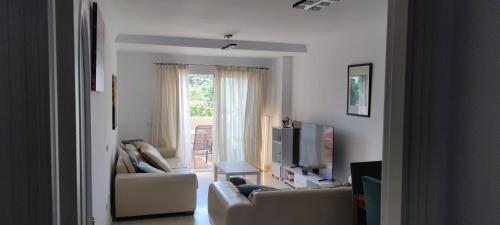 ein Wohnzimmer mit einem Sofa und einem TV in der Unterkunft Pinogolf de don Carlos, Marbella in Marbella