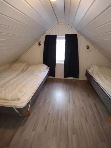 a room with two beds and a window in a tent at Hytte i skjærgården in Kristiansand