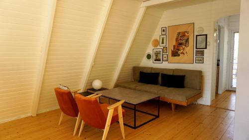 sala de estar con sofá, mesa y sillas en Domek Mały Las en Rzyki