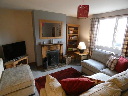 a living room with a couch and a fireplace at Shepherds Cottage in Shrewsbury