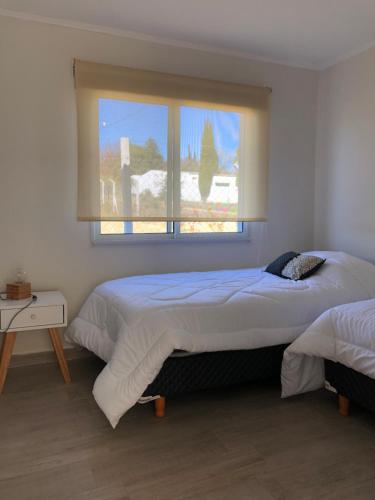 a bedroom with two beds and a window at Los Colibries II in San Pedro