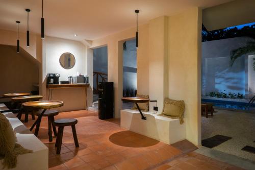 ein Restaurant mit Tischen und Stühlen und einer Küche in der Unterkunft Casa Rodina in Playa del Carmen