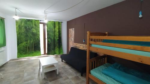 um quarto com um beliche e um sofá em cabañas bungalow albergue camping valle do seo em Trabadelo