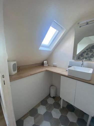 une salle de bain avec un lavabo et un miroir dans l'établissement Le Portel : Bel appartement à deux pas de la mer, à Le Portel