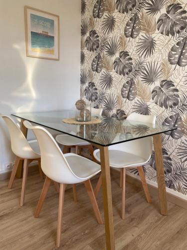 une salle à manger avec une table et des chaises en verre dans l'établissement Le Portel : Bel appartement à deux pas de la mer, à Le Portel