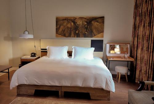 a bedroom with a large bed with white sheets at Atemporal by Andean in Lima