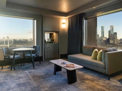 a living room filled with furniture and a large window at Pullman Melbourne On the Park in Melbourne