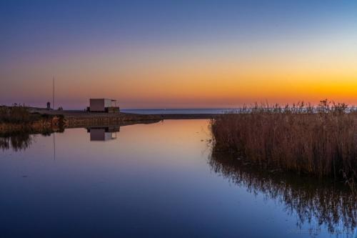 a sunset over a body of water with a dock at Apartamento Salgados Mar in Albufeira