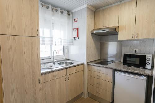 a small kitchen with a sink and a microwave at Urban Art by Campigir in Peniche