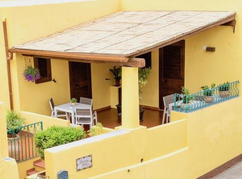a yellow house with a balcony with a table and chairs at Il Veliero Blu Lipari Centro - Guest House in Lipari