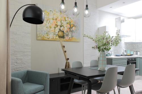 Un comedor con una mesa y un cuadro en la pared. en Altum Villare Apartments, en Rávena