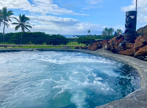a pool of water with palm trees in the background at Beachfront 1 Bedroom Condo with Private Beach, Pool, Hot Tub in Pahala