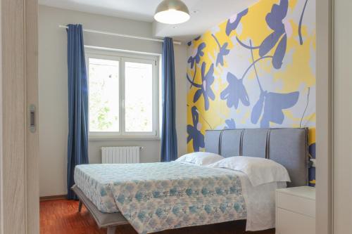 Un dormitorio con una cama con una pared azul y amarilla. en Altum Villare Apartments, en Rávena