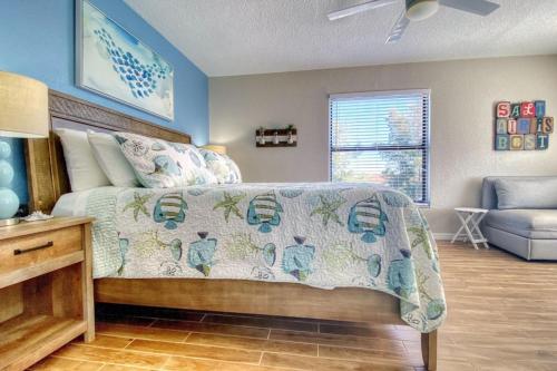 a bedroom with a bed with a comforter and a couch at The Pointe 301 in Clearwater Beach