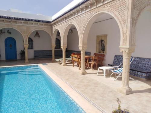 un patio con piscina en una casa en Maison typiques (houche) avec piscine en Houmt El Souk