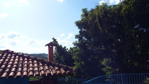 a roof of a house with a chimney and trees at Casa Agradável com piscina. in Miguel Pereira