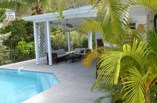 a patio with a swimming pool next to a house at Villa Fleur de Pirate in Orient Bay