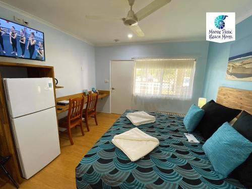 a kitchen and a living room with a bed and a refrigerator at Moore Park Beach Inn in North Coast