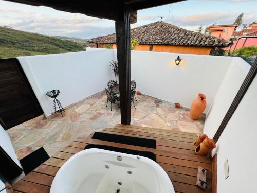 La salle de bains est pourvue d'une baignoire sur la terrasse. dans l'établissement Sonho Real Suítes, à Lavras Novas