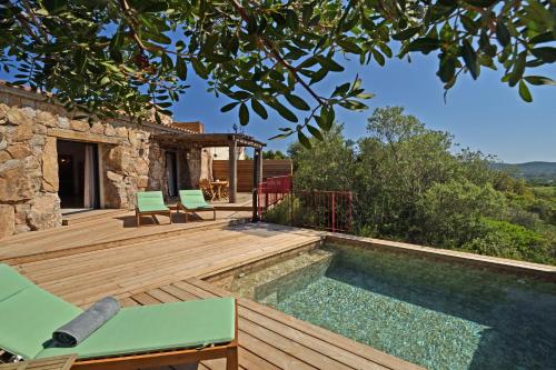 une terrasse en bois avec une piscine et une maison dans l'établissement Bergeries de charme Caselle di Conca, à Conca