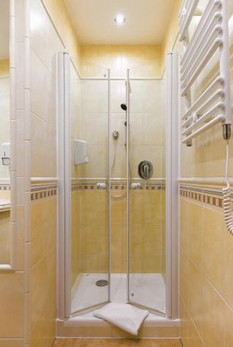 a shower with a glass door in a bathroom at Hotel Roudna in Plzeň