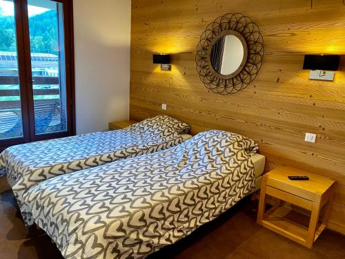 1 dormitorio con cama y espejo en la pared en Le REFUGE DES PORTES DU MONT BLANC en Vallorcine